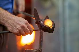 Image of glass being blown with tools